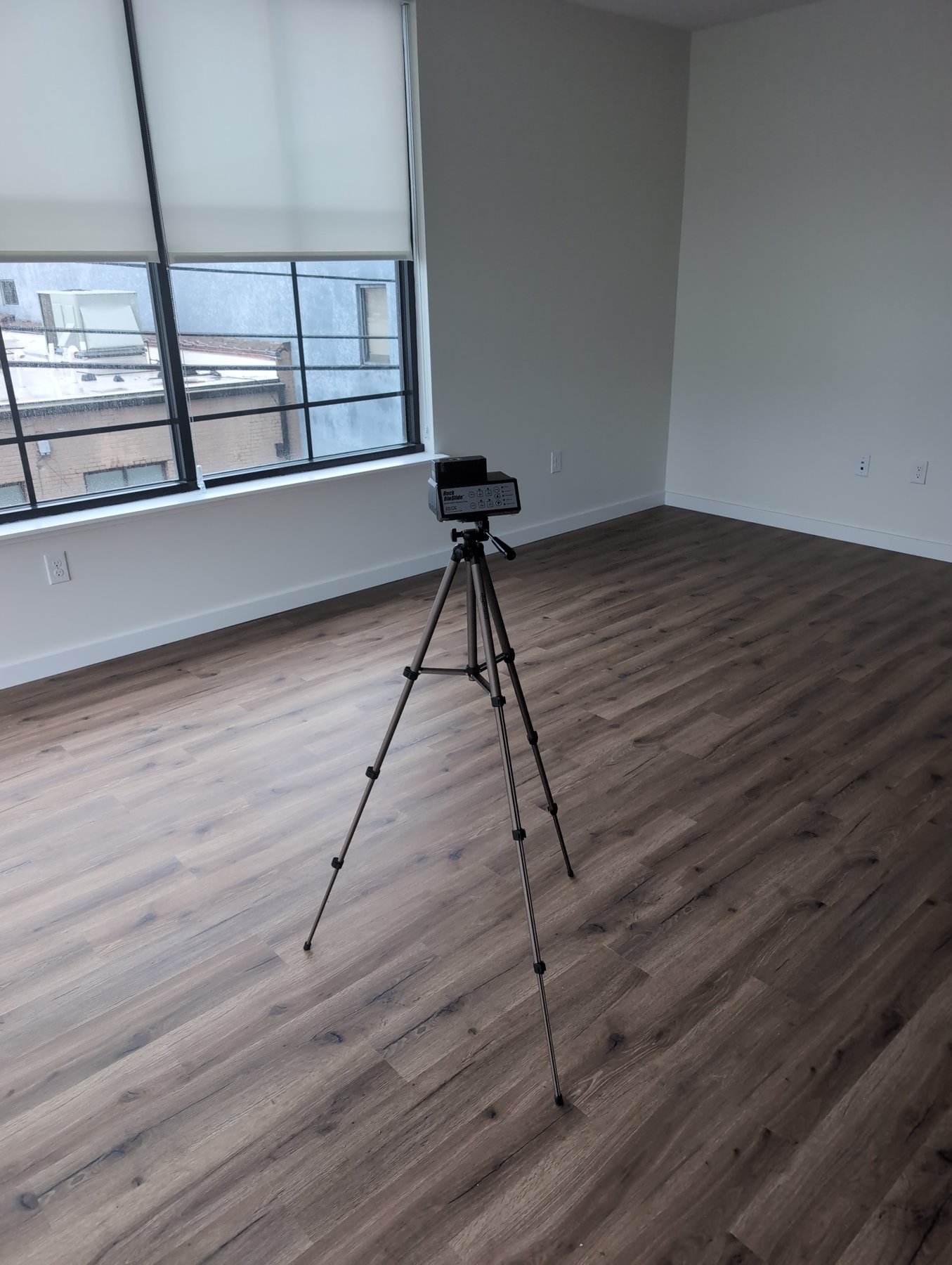 Air sampling pump on a tripod in an empty new apartment during clearance testing before turnover