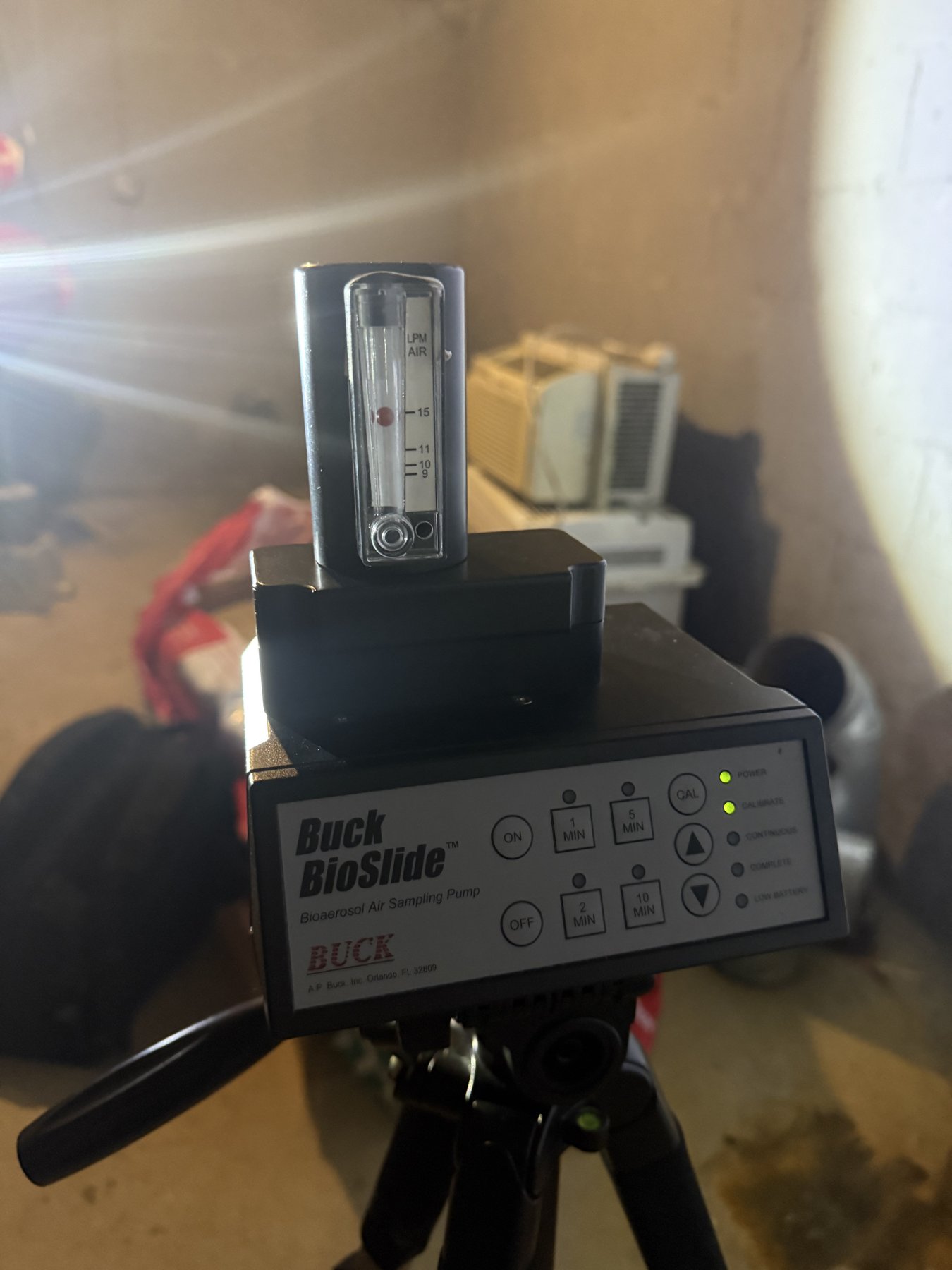 Buck BioSlide bioaerosol air sampling pump mounted on a tripod for mold spore trap sampling