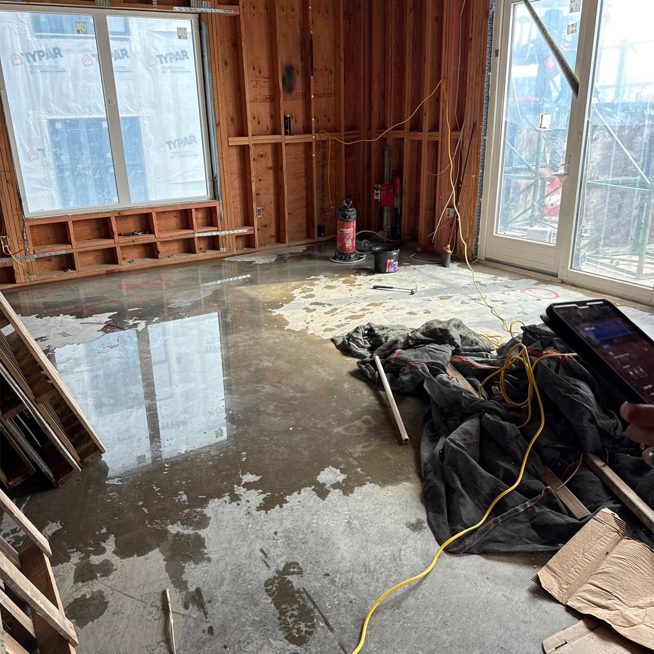Standing water on a concrete slab between wood framing after a storm at The Chasen Apartments construction site