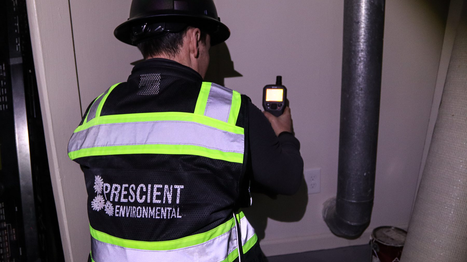 Inspector checking ductwork and mechanical equipment in a utility room for moisture and mold