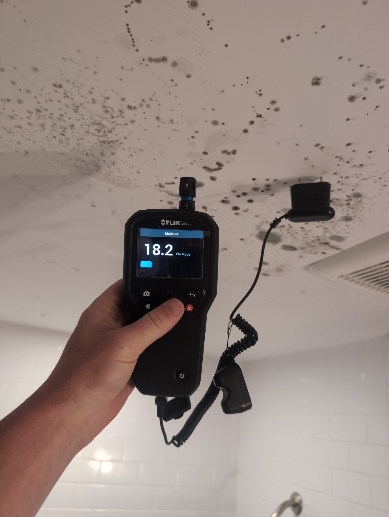 Prescient Environmental inspector taking a FLIR moisture reading on a ceiling with visible mold growth during a residential mold inspection