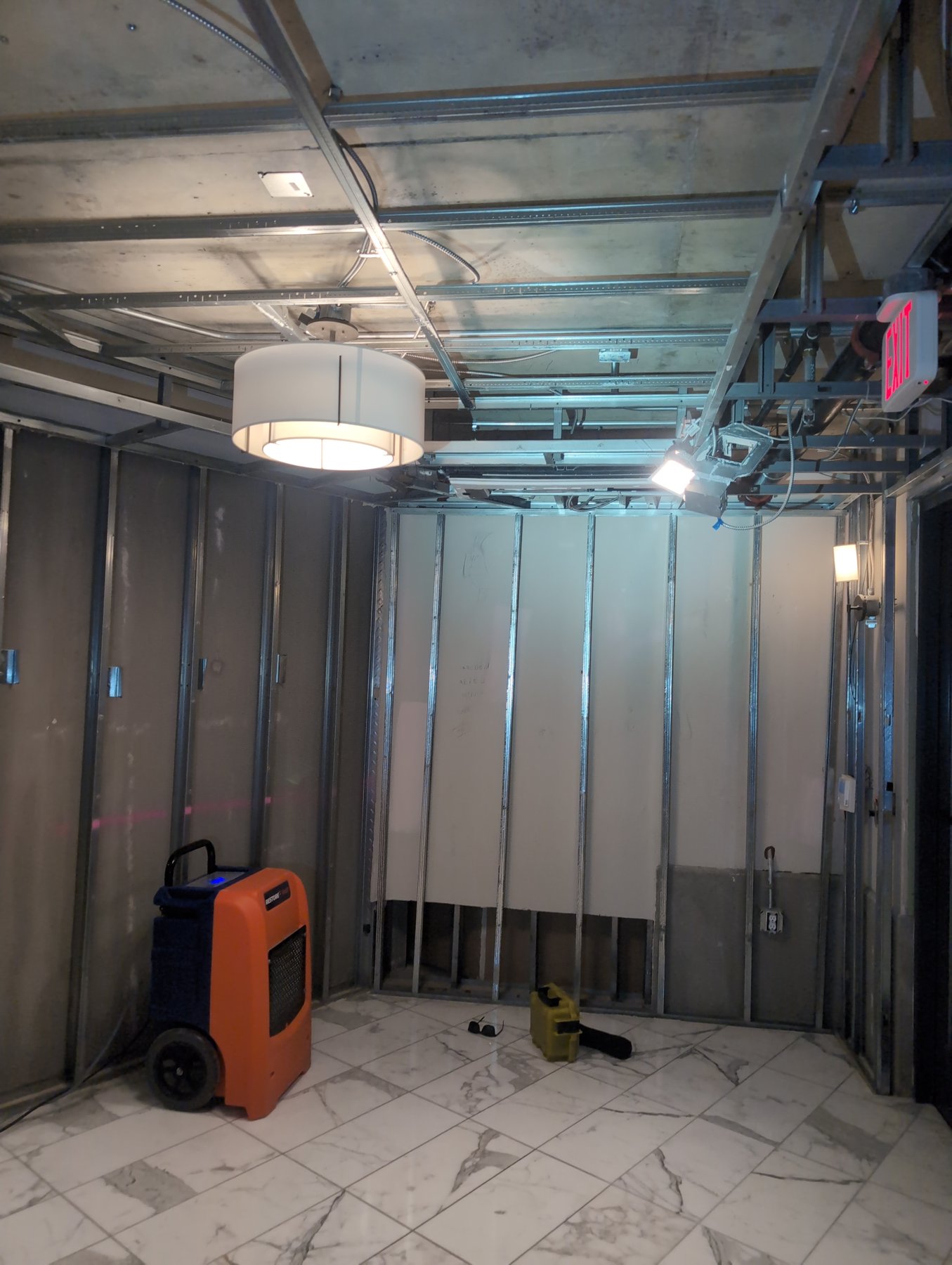 Metal stud walls opened for drying with a dehumidifier in a unit at The Ritz-Carlton Residences, Chevy Chase